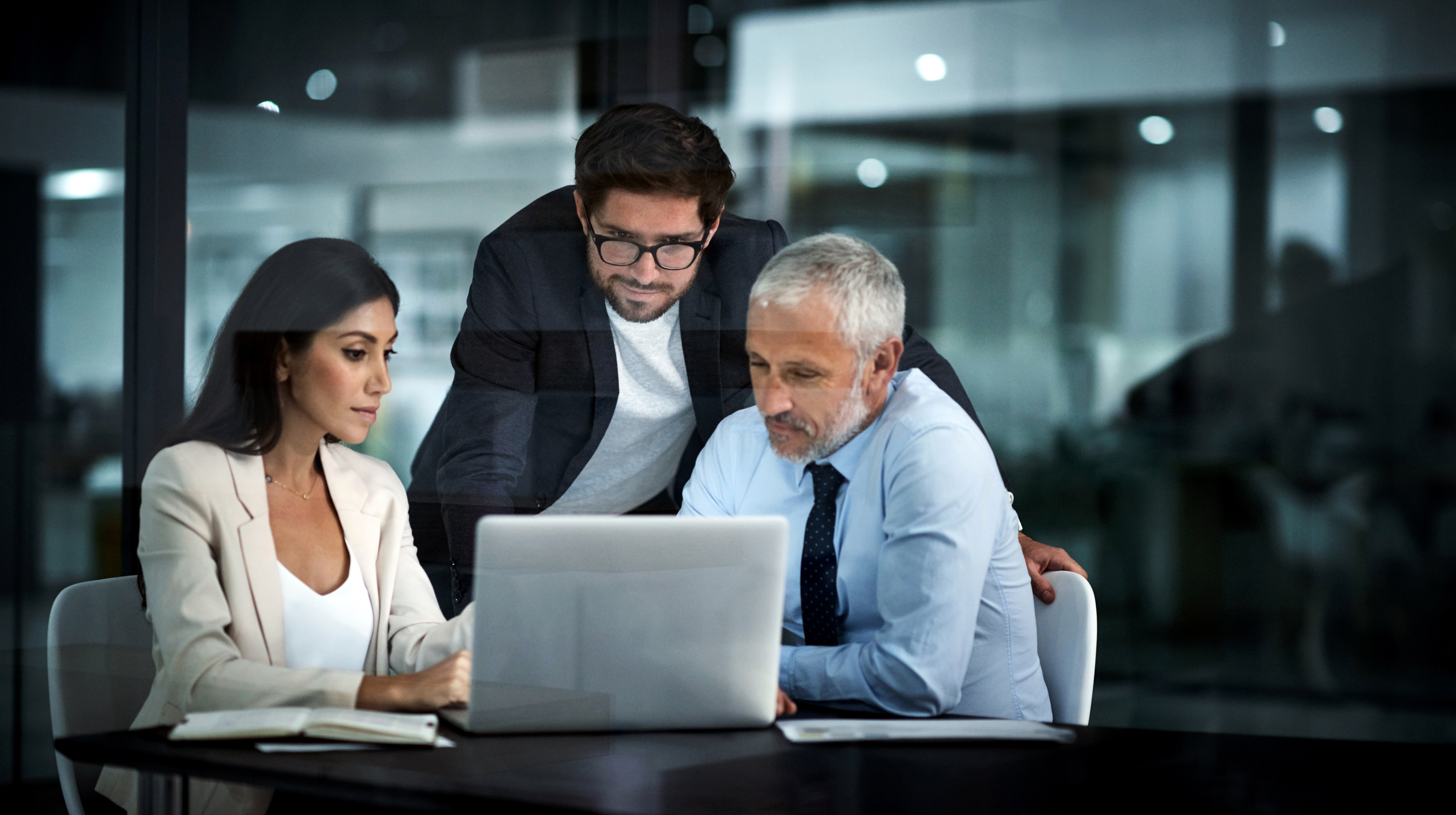 Three business people discuss their company's security measures to adequately protect trade secrets from data theft and encryption.