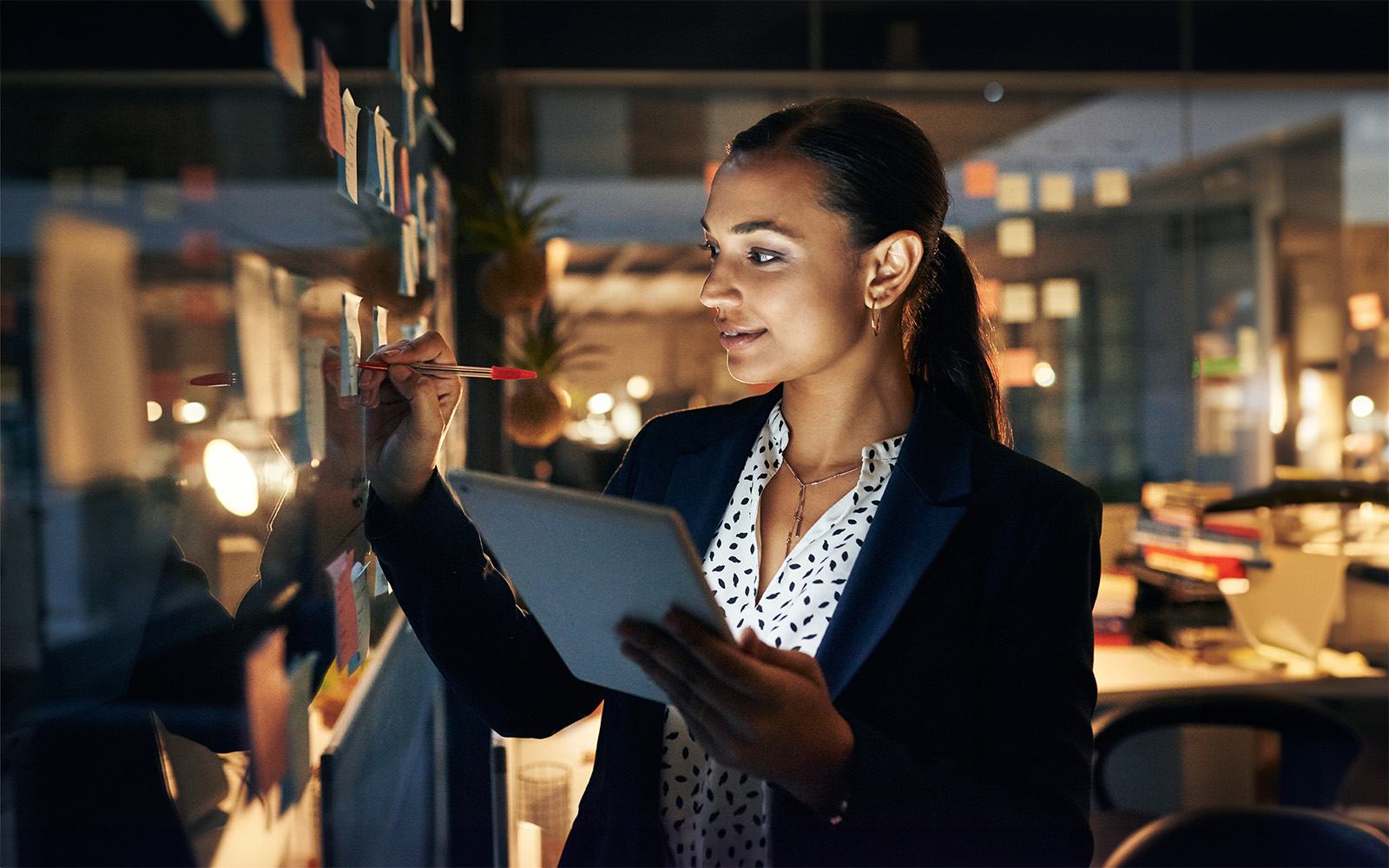 businesswoman-writing-adhesive-notes-on-glass-wall-1149848214