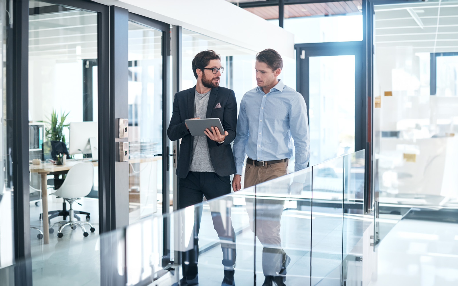 two-businessmen-using-tablet-961269498