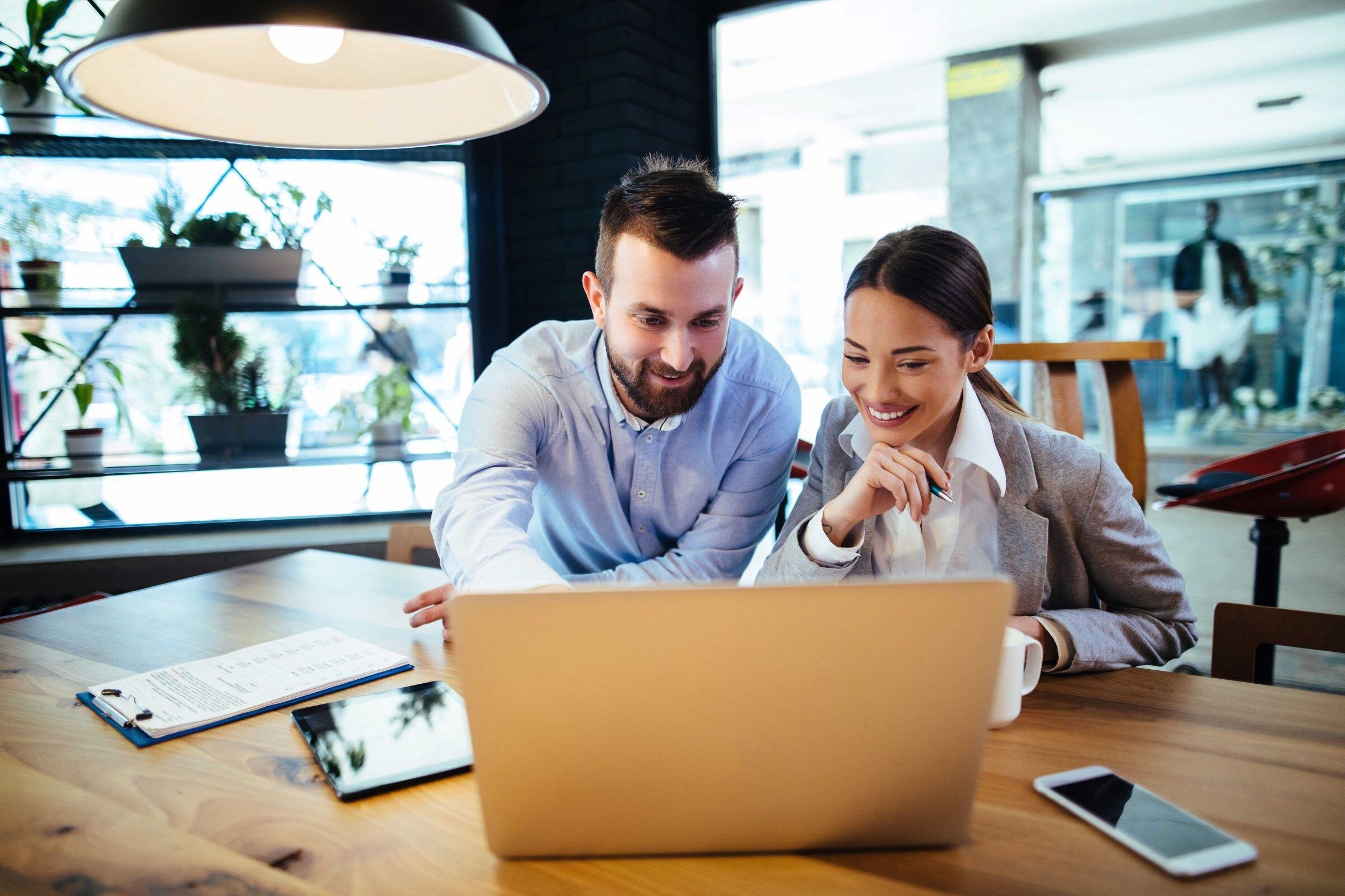 Man and woman sitting in front of a laptop screen
