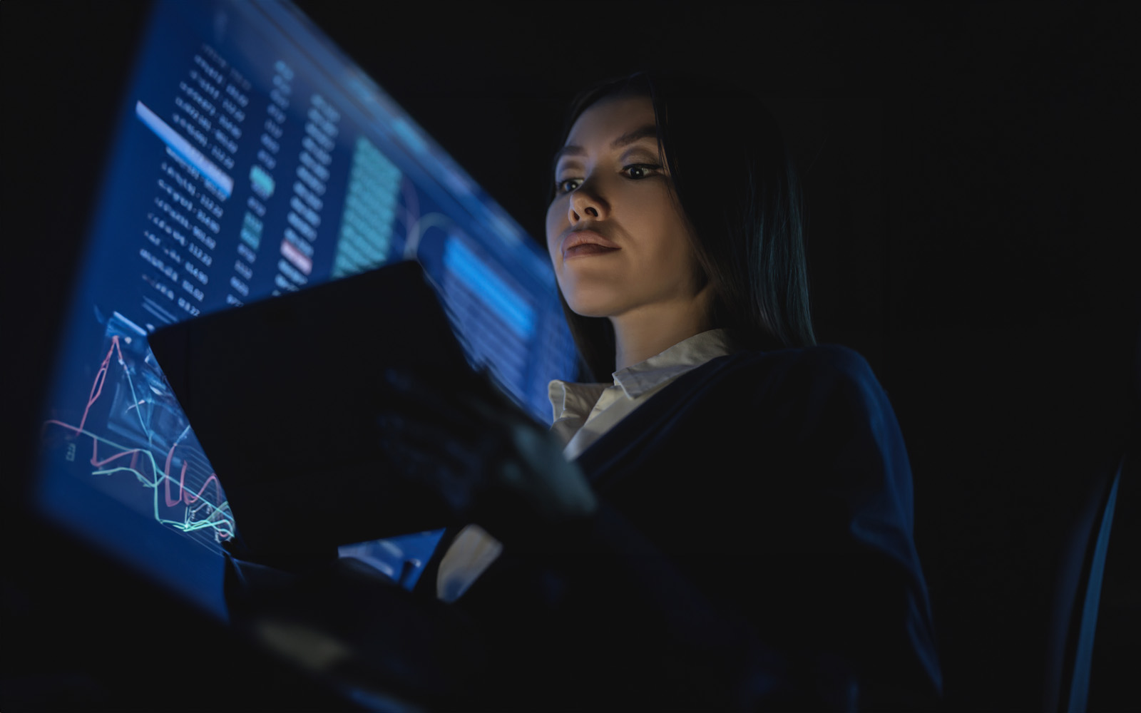 business-woman-holding-tablet-in-the-dark-1212375014