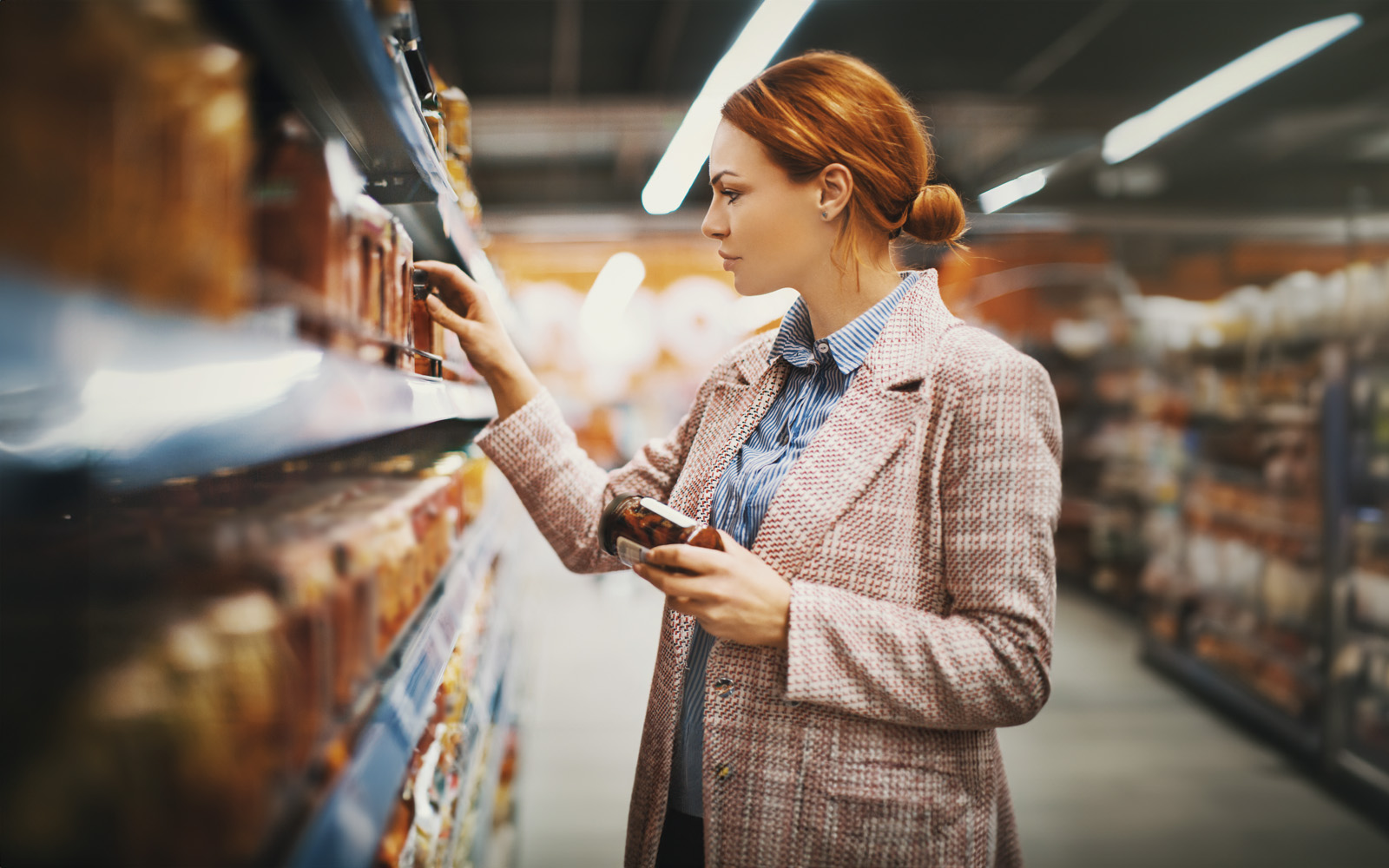 woman holding jar in supermarket