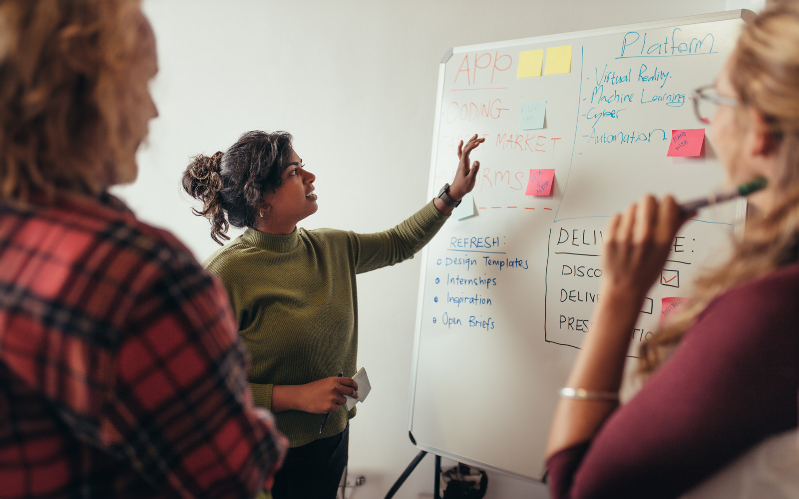 female-programmer-explaining-new-project-to-coworkers-1032708000
