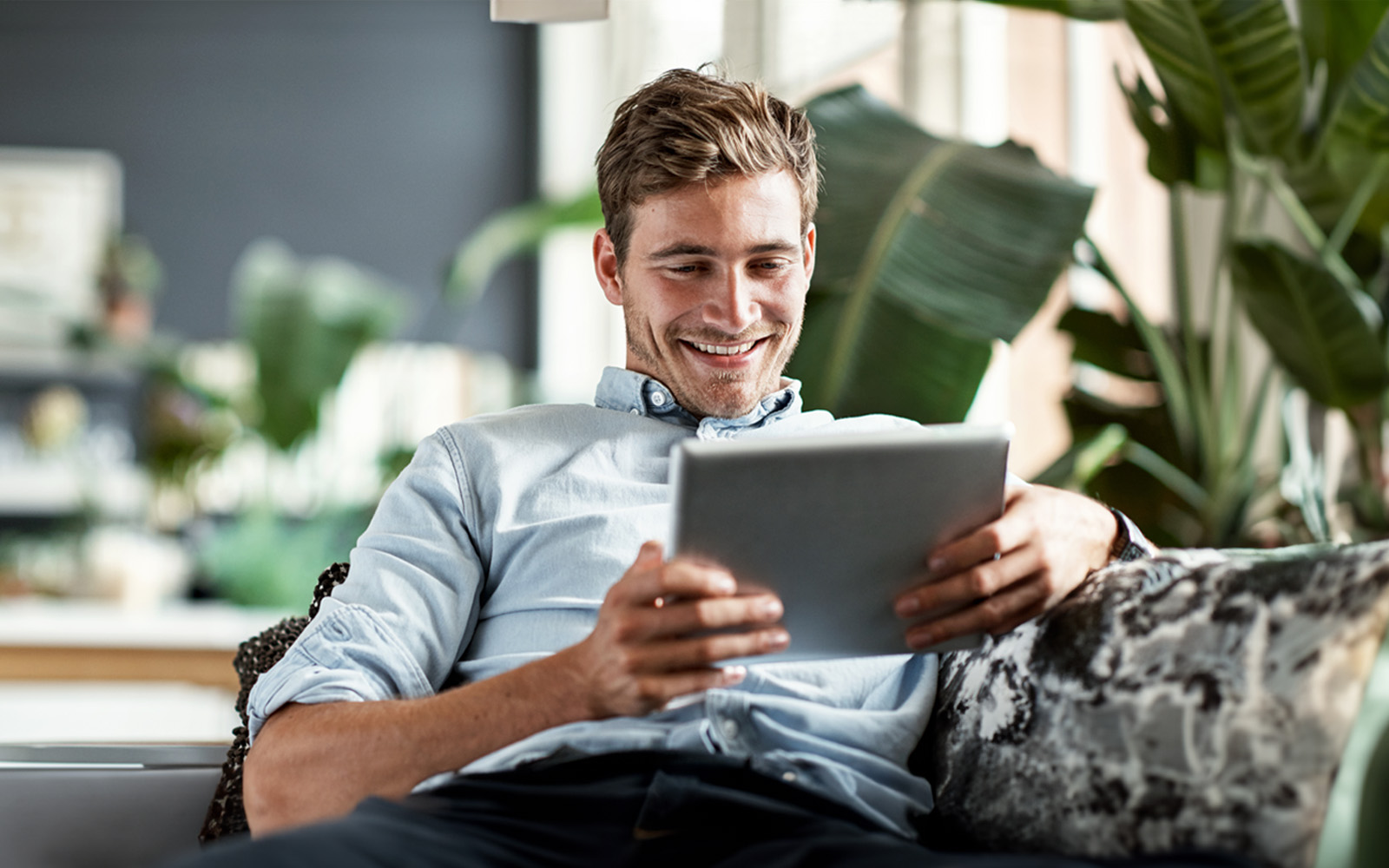 young-man-using-tablet-on-couch-640309910