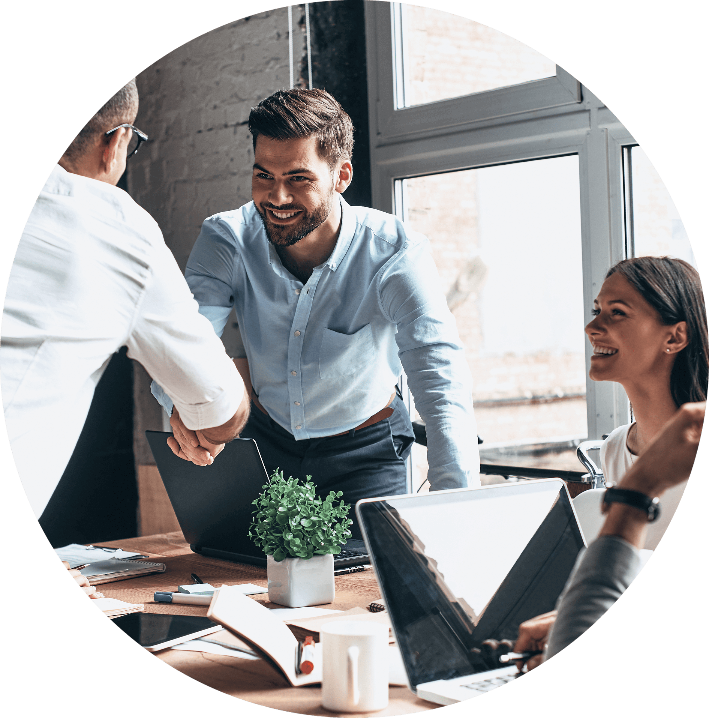 Geschäftliches Meeting mit Händedruck und Dokumenten auf dem Tisch.