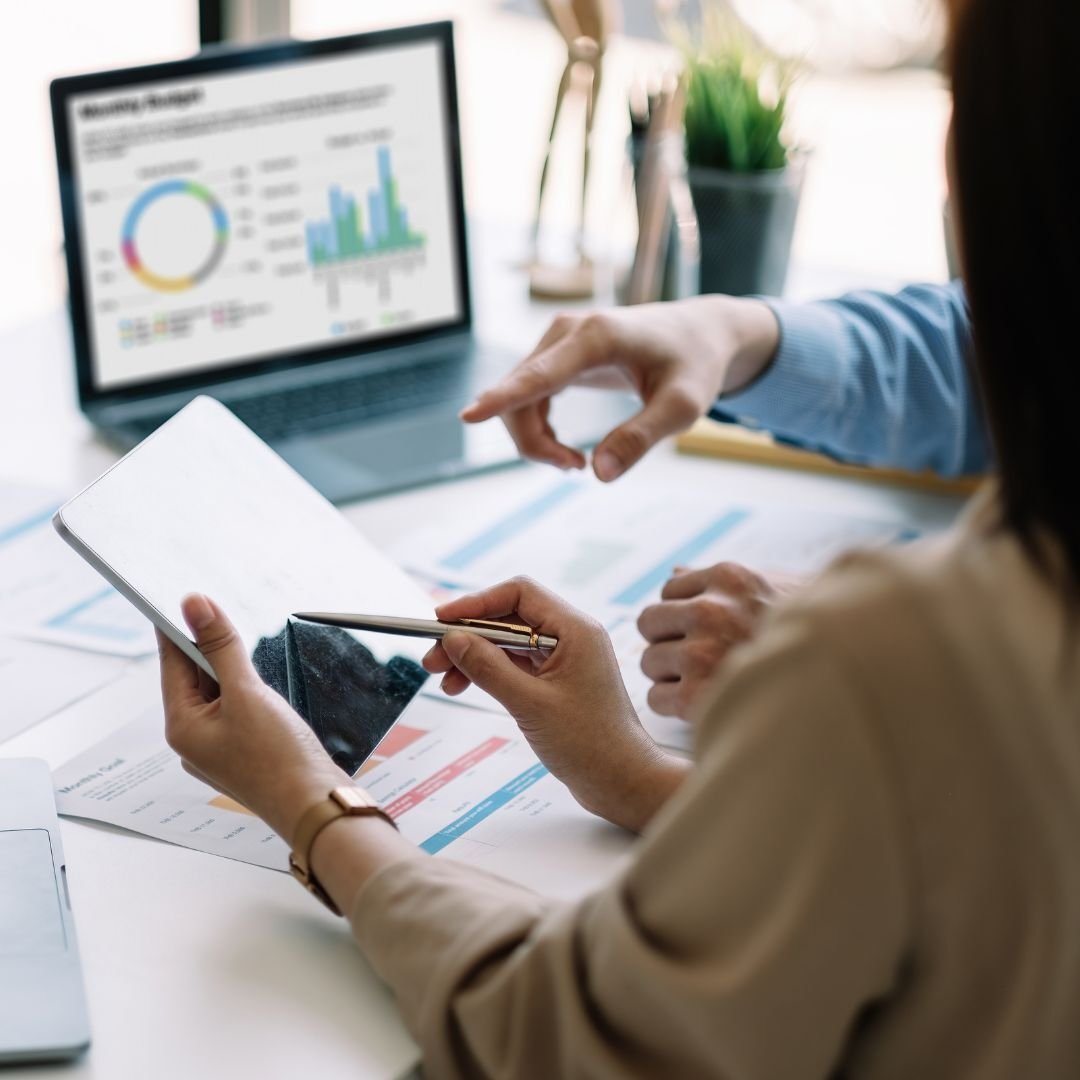 People sitting behind a desk looking at a data dashboard