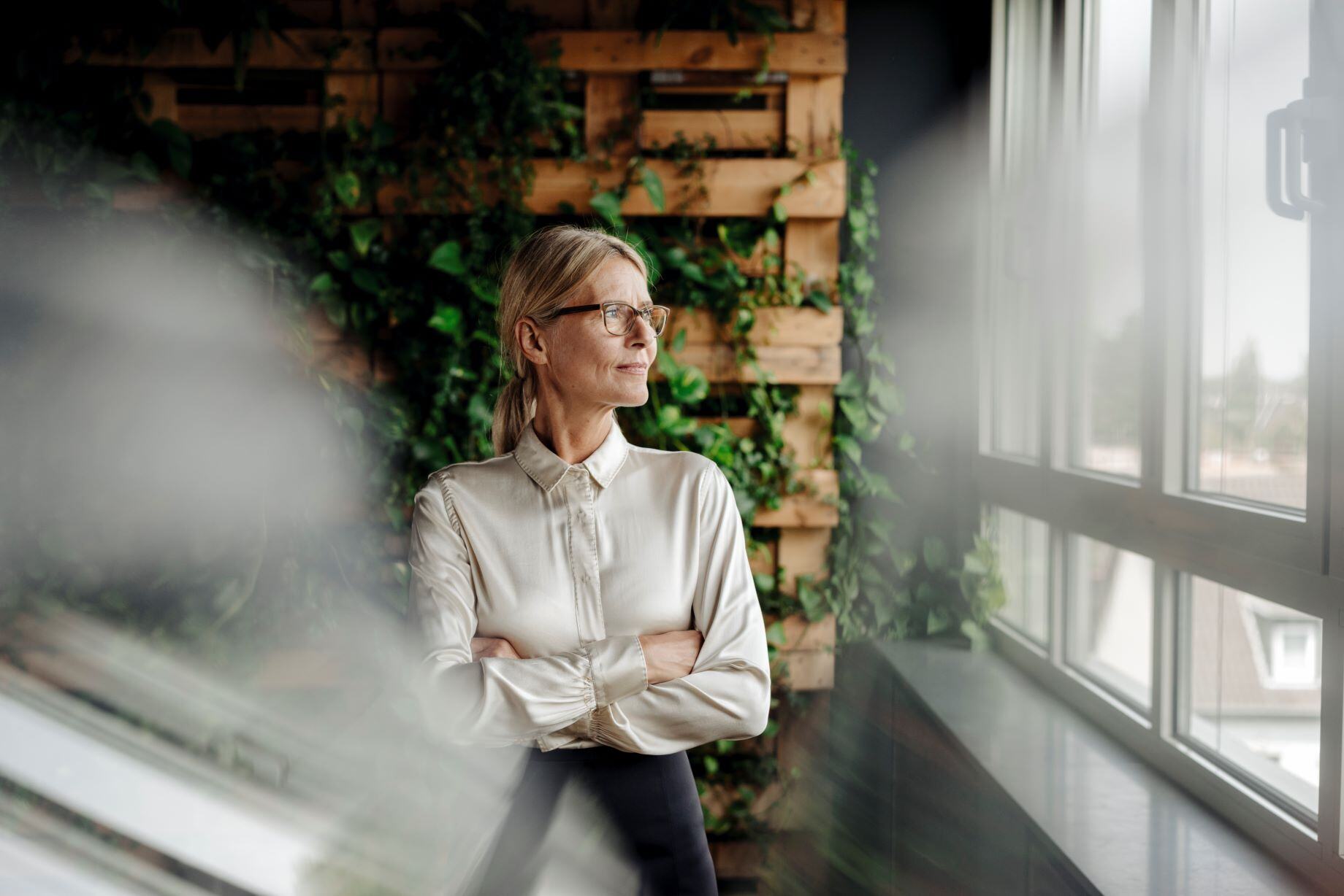 Business woman in a green office looking out of the window