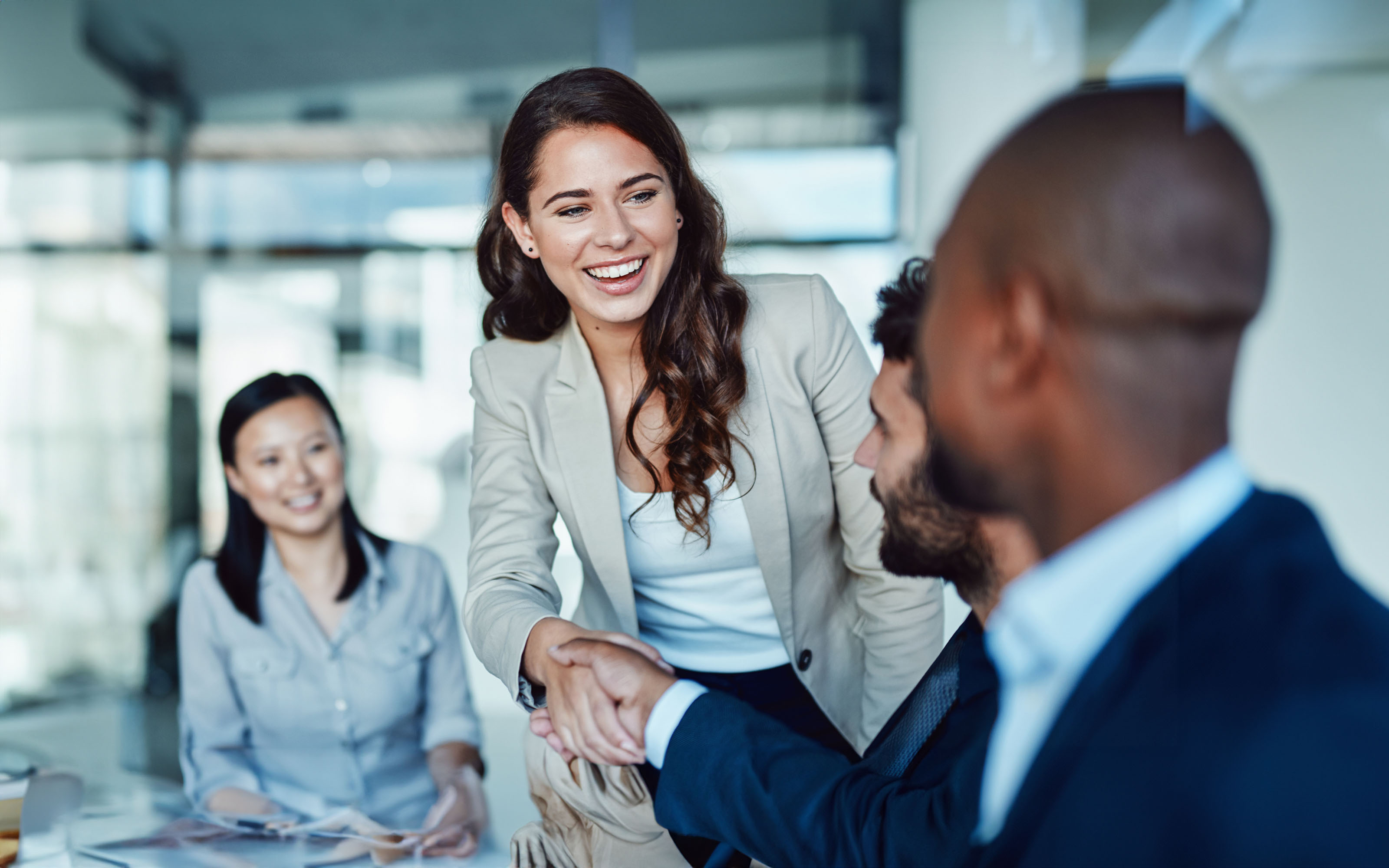 businesswoman-shaking-hands-with-a-colleague-during-a-meeting-1313807718