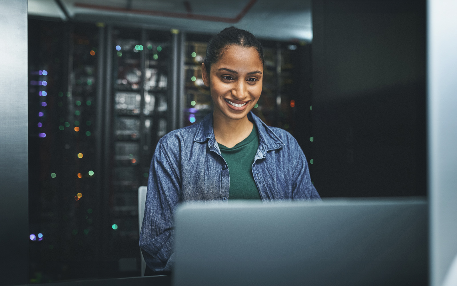 female-it-technician-in-a-server-room-using-laptop-1348968807