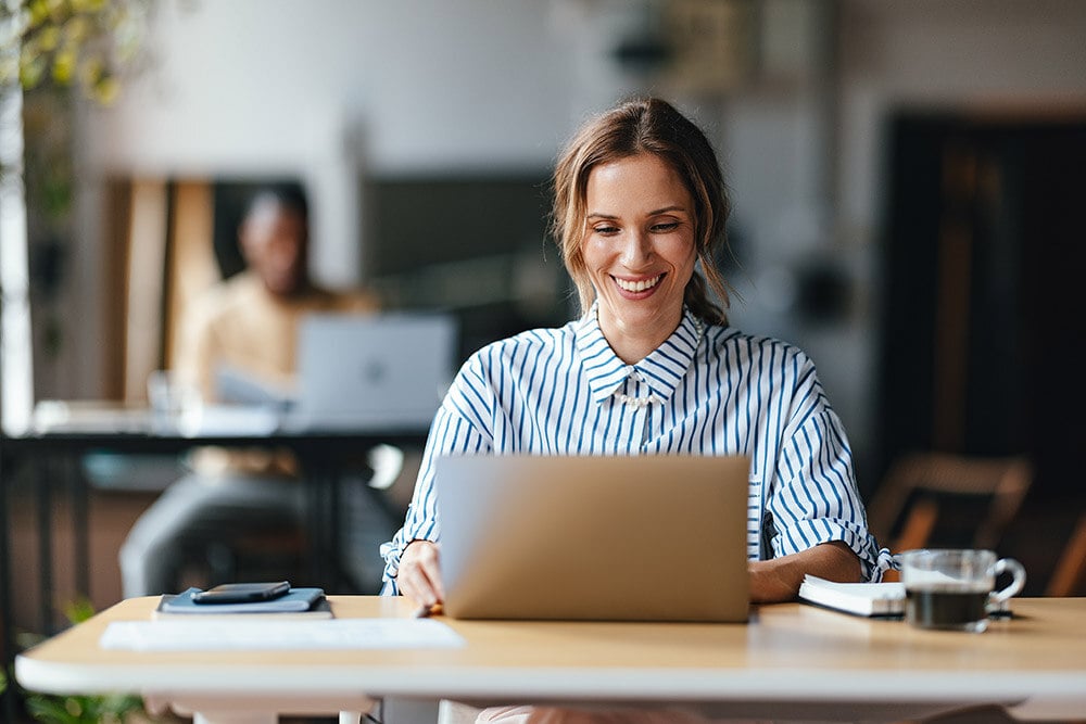frau-lacht-und-schaut-auf-ihrem-laptop