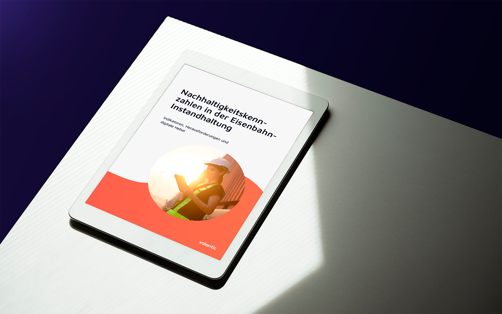 MockUp zum Bild: Eine Frau in Sicherheitsarbeitskleidung mit iPad vor einem Zugwaggon im warmen Licht des Sonnenuntergangs.